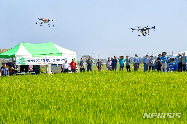 【고성(강원)=뉴시스】김경목 기자 = 24일 강원 고성군농업기술센터 관계자들이 고성군 죽왕면 야촌길 논에서 농업인들을 대상으로 농업용 드론을 활용한 벼 병해충 방제 시연회를 하고 있다. 2018.07.24. (사진=고성군청 제공)&nbsp; photo@newsis.com