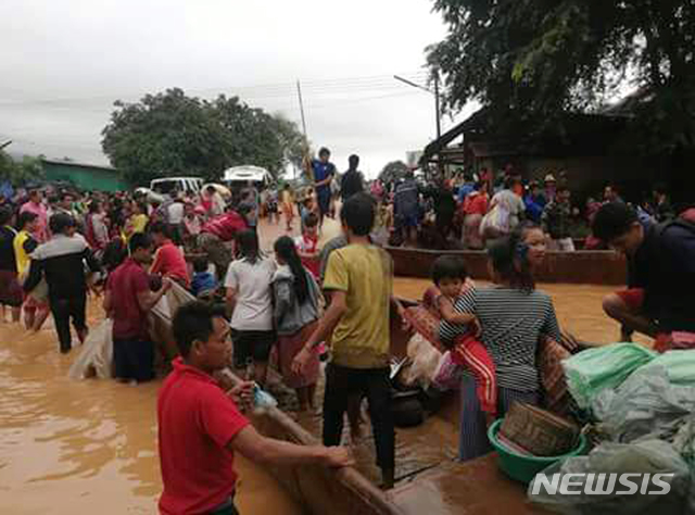 【아타프=AP/뉴시스】라오스 남동부 아타프 주에서 24일 주민들이 전날 세피안-세남노이 수력발전 댐이 붕괴해 홍수가 발생하자 배를 타고 안전지대로 이동하고 있다. 사진은 현지방송 아타프TV 동영상을 캡처한 것이다. 2018.07.25 