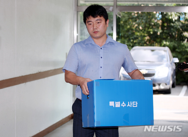 【서울=뉴시스】김진아 기자 = 국방부 특별수사단이 계엄령 검토 문건을 작성한 국군기무사령부 주요부처와 전현직 간부들의 자택 등을 압수수색한 25일 서울 용산구 국방부검찰단 별관에서 특수단 관계자가 압수물품을 들고 사무실로 들어가고 있다. 2018.07.25. bluesoda@newsis.com