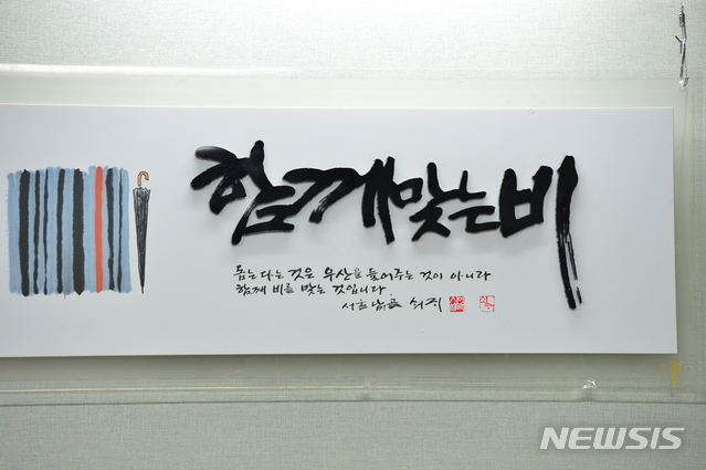 【창원=뉴시스】김기진 기자 = 26일 고(故) 노회찬 정의당 원내대표의 경남 창원시 성산구 지역구 사무실에 노 대표가 평소 좋아하던 '함께 맞는 비' 표구가 사무실 한 켠에 걸려 있다. 2018.07.26.&nbsp;&nbsp; sky@newsis.com