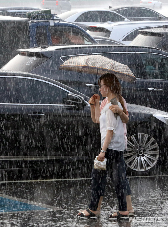 【천안=뉴시스】강종민 기자 = 폭염이 기승을 부린 27일 오후 충남 천안삼거리 휴게소에서 시민들이 갑자기 쏟아지는 비를 맞으며 이동하고 있다. 2018.07.29.&nbsp; ppkjm@newsis.com