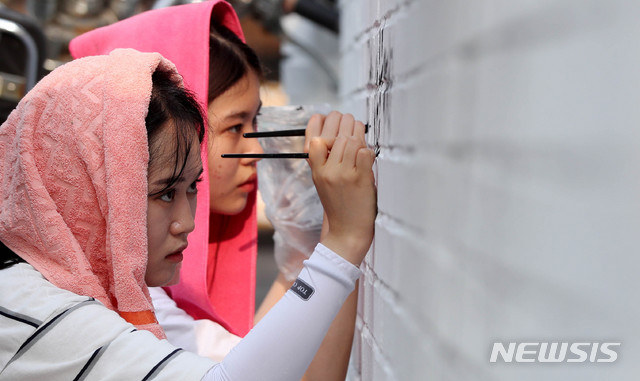 【서울=뉴시스】추상철 기자 = 벽화배달 네트워크 '벽의 민족' 학생들이 27일 오후 서울 영등포구 신길동 주택가에서 도시재생 '상생, 새로운 길을 걷다' 벽화대장정의 일환으로 무더위속 벽화를 그리고 있다. 2018.07.27. scchoo@newsis.com