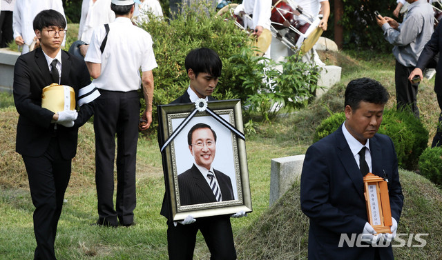 【남양주=뉴시스】홍효식 기자 = 지난 7월27일 오후 경기 남양주시 마석모란공원에서 열린 고 노회찬 정의당 원내대표의 하관식에서 유가족들이 영정과 유골함을 들고 장으로 향하고 있다. 2018.07.27. yesphoto@newsis.com