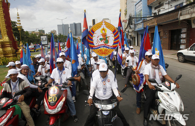 FILE - In this July 7, 2018, file photo, supporters of Cambodian Prime Minister Hun Sen's People's Party parade down a street during a campaign in Phnom Penh, Cambodia. Cambodians voting in the general election on Sunday, July 29, will have a nominal choice of 20 parties but in reality, only two serious options: extend Prime Minister Hun Sen’s 33 years in power or not vote at all. (AP Photo/Heng Sinith, File)