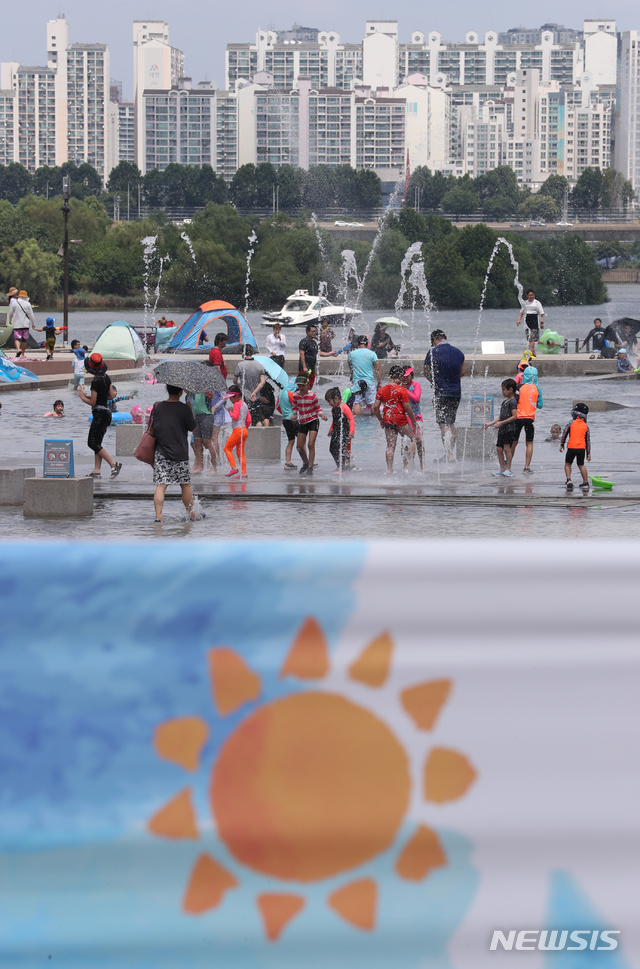 【서울=뉴시스】고승민 기자 = 중부지방에 폭염이 지속된 29일 오후 서울 여의도 물빛광장을 찾은 시민이 물놀이하며 즐거운 시간을 보내고 있다. 2018.07.29.&nbsp; kkssmm99@newsis.com 