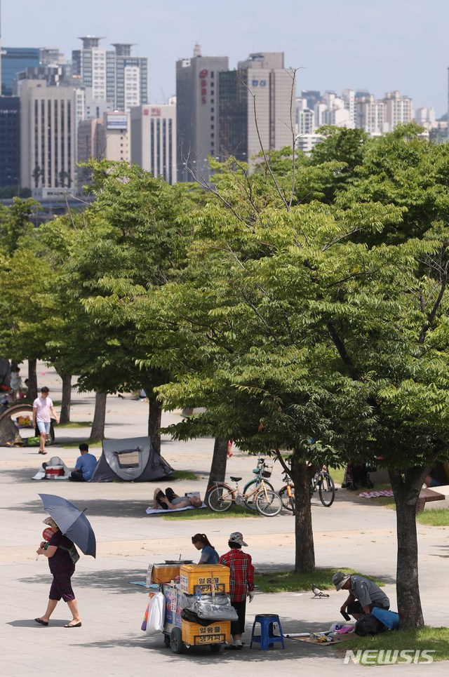 【서울=뉴시스】고승민 기자 = 폭염이 지속된 29일 오후 서울 여의도 물빛광장을 찾은 시민이 나무 아래 그늘막 텐트를 치고 더위를 나고 있다. .2018.07.29.&nbsp; kkssmm99@newsis.com