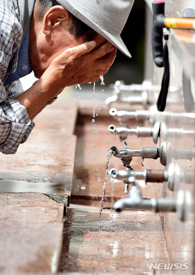 【대구=뉴시스】우종록 기자 = 연일 찜통더위가 이어지고 있는 31일 오후 대구시 중구 달성공원 수돗가에서 폭염에 지친 시민이 물을 마시며 더위를 식히고 있다. 2018.07.31.&nbsp; wjr@newsis.com 