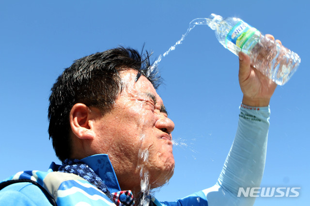 【화천=뉴시스】한윤식 기자 = 1일 오후 강원 화천 북한강 쪽배축제장에서 열린 화천군청 공무원 용선경주대회를 마친 공무원이 얼굴에 물을 뿌리며 더위를 식히고 있다. 이날 오후 홍천 기온이 40.6도까지 치솟으며 우리나라 기상관측 역대 최고 온도를 기록했다. 2018.08.01. ysh@newsis.com