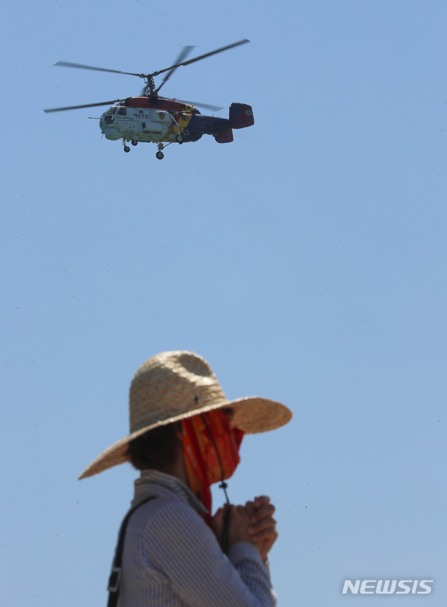 【제주=뉴시스】우장호 기자 = 제주에 관광 온 30대 여성이 실종된 지 7일이 지난 가운데 1일 오전 제주시 구좌읍 세화리 세화포구 인근 상공을 수색하는 제주해경 소속 헬기 아래로 실종자 가족이 나와 기도하고 있다. 2018.08.01.&nbsp; woo1223@newsis.com 