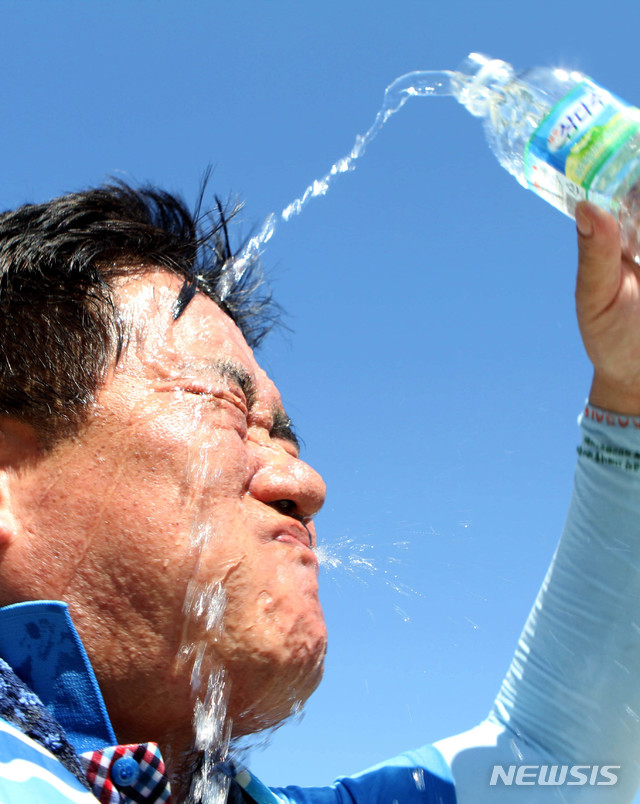 【화천=뉴시스】한윤식 기자 = 1일 오후 강원 화천 북한강 쪽배축제장에서 열린 화천군청 공무원 용선경주대회를 마친 공무원이 얼굴에 물을 뿌리며 더위를 식히고 있다. 이날 오후 2시 1분께 홍천 기온이 40.3도까지 치솟으며 우리나라 기상관측 역대 최고 온도를 기록했다. 2018.08.01. ysh@newsis.com