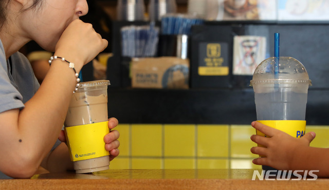 【서울=뉴시스】김선웅 기자 = 1일 서울 시내의 한 커피 전문점에서 고객들이 매장이 제공한 일회용컵을 사용하고 있다. 당초 환경부는 이날부터 카페 내 일회용컵 사용에 대한 과태료를 부과할 계획이었으나 단속 시점을 연기했으며 오는 2일 부터 단속을 시작할 예정이다. 2018.08.01.&nbsp; mangusta@newsis.com