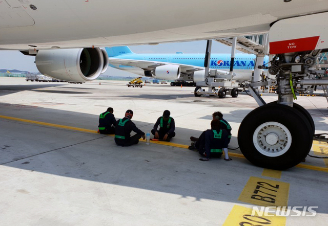 【인천공항=뉴시스】 111년만의 최악의 폭염이 한반도를 강타한 가운데 인천공항 내 계류장에서 근무하는 지상조업 관계자들이 항공기 동체 그늘에서 잠시 휴식을 취하고 있다. 2018.08.02.(사진=독자 제공) photo@newsis.com