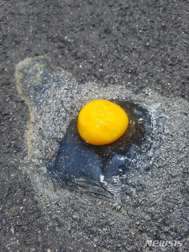 【인천공항=뉴시스】 최악의 폭염이 한반도를 강타한 가운데 인천공항 내 계류장에서 근무하는 지상조업 관계자들은 폭염에 그대로 노출돼 있다. 이들은 계류장이 얼마나 뜨거운지 실험하기 위해 아스팔트에 날계란을 깨뜨렸다. 그 결과 흰자는 증발하고 노른자는 반숙이 됐다고 전했다. 2018.08.02.(사진=독자 제공)&nbsp; photo@newsis.com