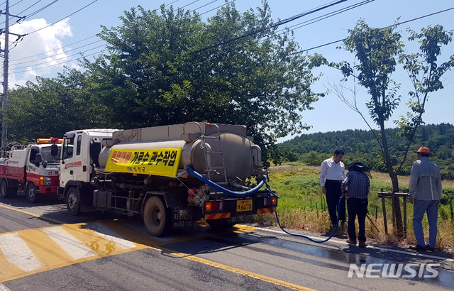 【신안=뉴시스】박상수 기자 = 전남 신안군은 최근 폭염이 지속되면서 가로수와 소공원 등 가뭄으로 피해가 예상되는 주요도로변 약 105㎞구간의 가로수 등에 관수작업을 실시하고 있다고 2일 밝혔다. 사진은 가로수 물주기 작업. 2018.08.02. (사진=신안군 제공) photo@newsis.com