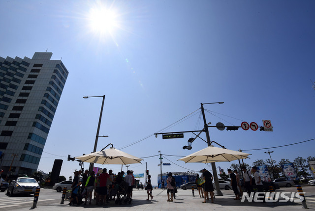 【부산=뉴시스】 하경민 기자 = 부산지역에 폭염특보가 23일째 지속되고, 열대야 현상도 16일째 발생하는 등 밤낮으로 폭염이 기승을 부리고 있는 가운데 2일 오전 부산 해운대해수욕장 입구 횡단보도에 설치된 그늘막에서 피서객들이 땡볕을 피하고 있다. 2018.08.02.&nbsp; yulnetphoto@newsis.com