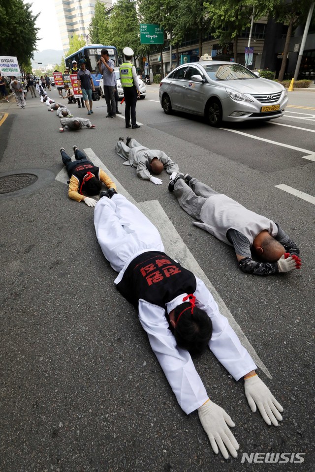 【서울=뉴시스】조성봉 기자 = 2일 오후 서울 종로구 조계사에서 대한문까지 김득중(왼쪽) 쌍차 지부장을 비롯한 참가자들이 쌍용자동차 해고자 복직을 위한 오체투지(五體投地)를 하고 있다. 오체투지는 몸의 다섯 부분(두 팔꿈치, 두 무릎, 이마)이 땅에 닿도록 엎드려 하는 절을 말한다. 이날 오체투지는 조계종 사회노동위원회 스님들과 쌍용자동차 해고자, KTX 여승무원 등 노동자와 시민들이 함께했다. 2018.08.02.suncho21@newsis.com