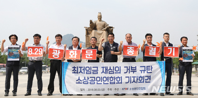 【서울=뉴시스】김진아 기자 = 소상공인연합회 관계자들이 3일 서울 종로구 광화문광장에서 열린 최저임금 재심의 거부 규탄 기자회견에서 구호를 외치고 있다. 고용노동부는 이날 소상공인, 경제단체 등의 내년도 최저임금 재심의 요청을 거부했다. 이로써 내년 최저임금은 올해보다 10.9% 오른 시급 8350원으로 확정됐다. 이에 소상공인연합회는 기자회견을 통해 오는 8월 29일에 '전국 소상공인 총궐기'에 나서는 등 직접 행동에 돌입하겠다고 밝혔다. 2018.08.03. bluesoda@newsis.com