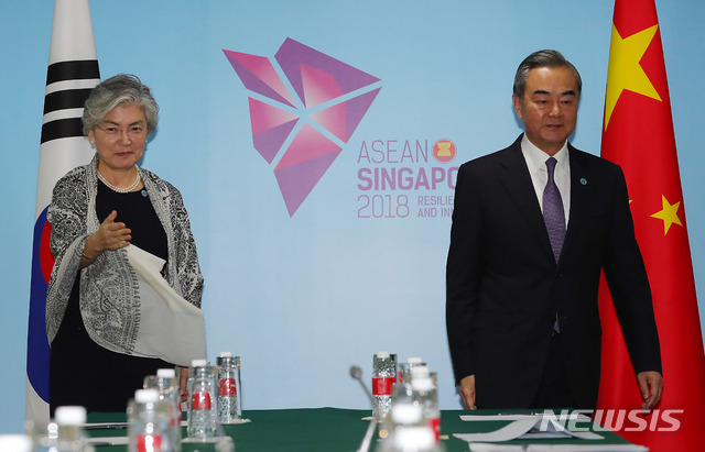 【싱가포르=뉴시스】배훈식 기자 = 2018 아세안지역안보포럼(ARF)에 참석한 강경화(왼쪽) 외교부 장관이 3일 오후 싱가포르 엑스포 컨벤션센터에서 왕이 중국 외교담당 국무위원 겸 외교부장과 양자회담 전 악수한 뒤 자리를 권하고 있다. 2018.08.03.&nbsp; dahora83@newsis.com