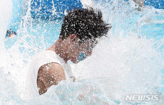 【서울=뉴시스】임태훈 기자 = 4일 오후 서울 마포구 난지한강공원 젊음의 광장에서 열린 '2018 한강 물싸움 축제'에 참가한 시민들이 물미끄럼틀을 타며 더위를 이겨내고 있다. 2018.08.04.&nbsp; taehoonlim@newsis.com