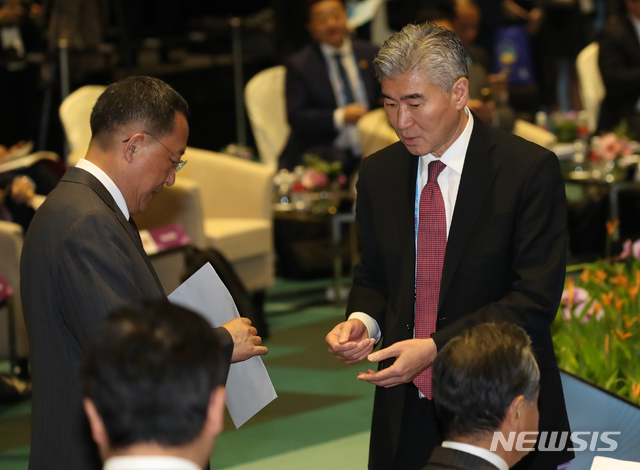 【싱가포르=뉴시스】배훈식 기자 = 4일 오후 싱가포르 엑스포 컨벤션센터에서 열린 2018 아세안외교안보포럼(ARF)에 참석한 리용호(왼쪽) 북한 외무상이 성 김 주필리핀 미국 대사가 건넨 서류를 들고 대화하고 있다. 2018.08.04.&nbsp; photo@newsis.com