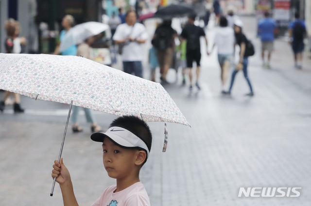 【서울=뉴시스】최동준 기자 = 5일 서울 중구 명동거리에서 한 외국인 관광객이 내리는 소나기에 우산을 쓰고 있다. 2018.08.05.&nbsp; photocdj@newsis.com