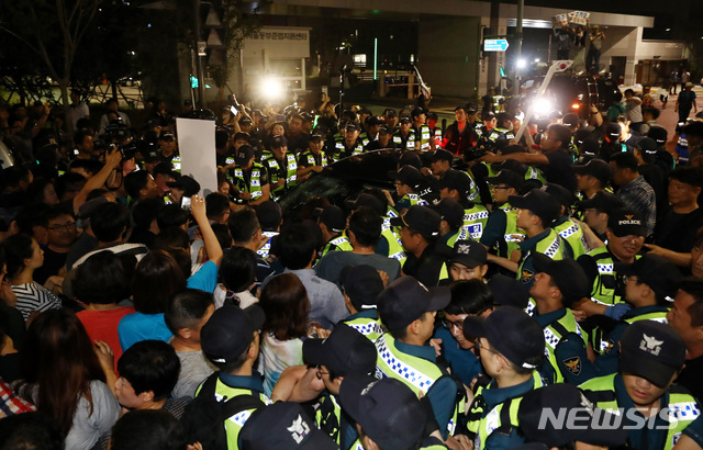 【서울=뉴시스】이영환 기자 = 김기춘 전 청와대 비서실장이 석방돼 6일 새벽 서울 송파구 동부구치소를 나서 차량에 탑승하자 석방을 반대하는 시민들이 막아서고 있다. 문화·예술계 블랙리스트 작성을 지시한 혐의로 구속된 김 전 비서실장은 지난달 27일 구속기간이 만료됨에 따라 대법원이 직권구속취소 결정을 내려 562일만에 출소했다. 2018.08.06. 20hwan@newsis.com