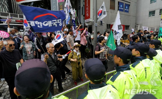 【서울=뉴시스】고범준 기자 = 김경수 경남도지사가 드루킹 댓글 조작 의혹 사건과 관련해 피의자 신분으로 조사를 받기 위해 6일 오전 서울 서초구에 마련된 허익범 특별검사팀으로 출석 한 가운데 보수단체 회원들이 김 지사의 구속을 촉구하며 태극기를 흔들고 있다. 2018.08.06. bjko@newsis.com