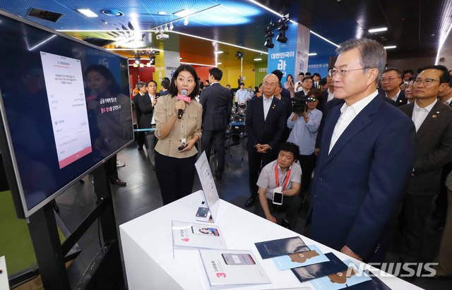 【서울=뉴시스】전신 기자 = 문재인 대통령이 7일 서울 중구 서울시 시민청 활짝라운지에서 열린 인터넷 전문은행 규제혁신 현장 간담회를 마친 후 케이뱅크 부스에서 스마트폰을 이용해 계좌개설 하는 방법에 대해 설명 듣고 있다. 2018.08.07.&nbsp; photo1006@newsis.com