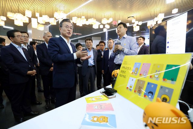 【서울=뉴시스】전신 기자 = 문재인 대통령이 7일 서울 중구 서울시 시민청 활짝라운지에서 열린 인터넷 전문은행 규제혁신 현장 간담회를 마친 후 카카오뱅크 부스에서 모바일로 전월세 보증금을 대출 받는 과정에 대해 설명 듣고 있다. 2018.08.07.&nbsp; photo1006@newsis.com