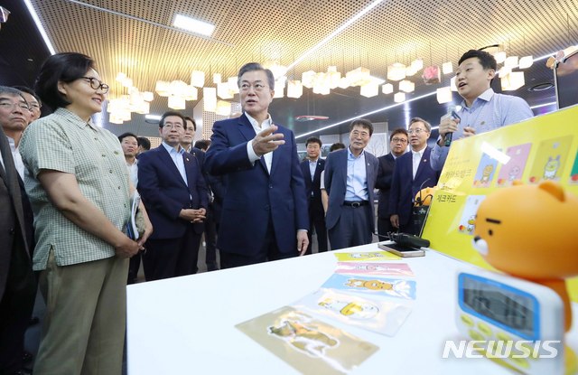 【서울=뉴시스】전신 기자 = 문재인 대통령이 7일 서울 중구 서울시 시민청 활짝라운지에서 열린 인터넷 전문은행 규제혁신 현장 간담회를 마친 후 카카오뱅크 부스에서 모바일로 전월세 보증금을 대출 받는 과정에 대해 설명 듣고 있다. 2018.08.07. photo1006@newsis.com