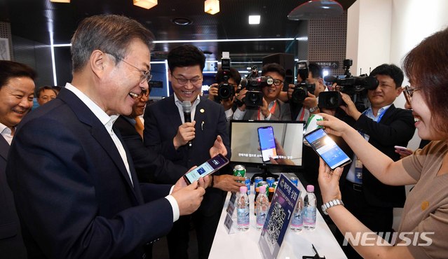 【서울=뉴시스】전신 기자 = 문재인 대통령이 7일 서울 중구 서울시 시민청 활짝라운지에서 열린 인터넷 전문은행 규제혁신 현장 방문 행사를 마친 후 페이콕 부스에서 핀테크 기술을 활용한 QR코드 결제 방식에 대해 설명 듣고 시연하고 있다. 2018.08.07.&nbsp; photo1006@newsis.com