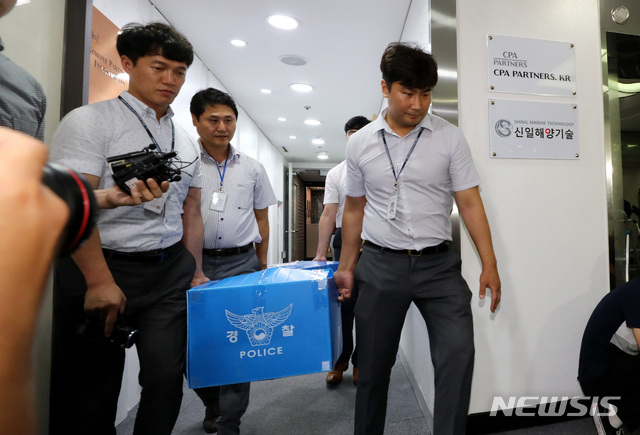 【서울=뉴시스】이영환 기자 = 보물선으로 알려진 러시아 순양함 '돈스코이호' 투자 사기 의혹 사건과 관련해 신일그룹(현 신일해양기술) 압수수색을 마친 경찰이 7일 오후 서울 영등포구 신일그룹 사무실에서 압수물품을 옮기고 있다. 서울경찰청 지능범죄수사대는 이날 오전 8시30분께부터 전담수사팀 등 27명을 동원해 서울 영등포구 신일그룹과 서울 강서구 신일그룹 돈스코이호국제거래소를 포함한 8곳을 압수수색했다. 2018.08.07. 20hwan@newsis.com