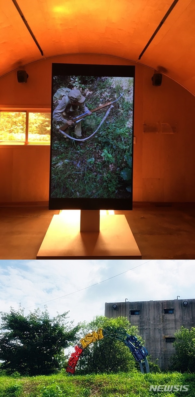 【서울=뉴시스】 박현주 미술전문기자 = 미디어작가 박찬경의 '소년병'과(위), 캠프그리브스 입구에 설치된 인세인박의 네온조각 'ISM!'ISM!'ISM!'.