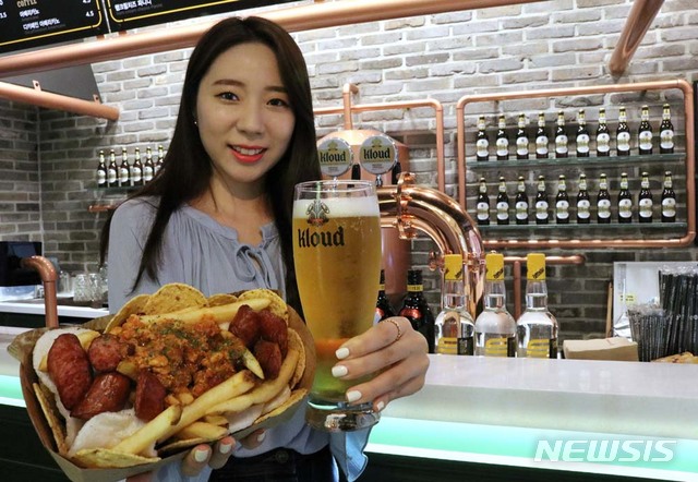 [서울=뉴시스] 낮 기온이 30도를 웃도는 본격적인 여름 더위가 기승을 부리면서 치킨과 맥주의 계절이 됐다. 하지만 덥다고 '치맥'을 자주 즐기면 체내에 요산이 과다 축적돼 발생하는 관절염인 통풍(痛風)이 유발될 수 있다. 사진은 모델이 '시네마 라운지'를 소개하는 모습. 2018.08.08. (사진=롯데주류 제공. 기사와 관련이 없습니다.) photo@newsis.com