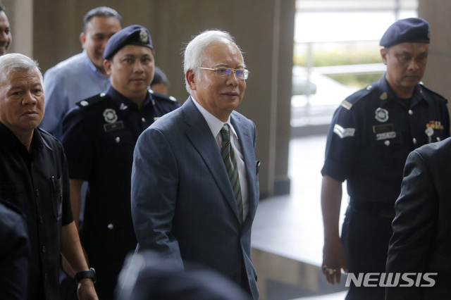 【쿠알라룸푸르(말레이시아)=AP/뉴시스】나집 라작 전 말레이시아 총리(가운데)가 8일 쿠알라룸푸르의 말라야 고등법원에 도착하고 있다. 나집 전 총리는 이날 말레이시아 국부펀드 1MDB로부터 수십억 달러를 포탈한 것과 관련해 3건의 돈세탁 혐의로 고소당했다. 2018.8.8