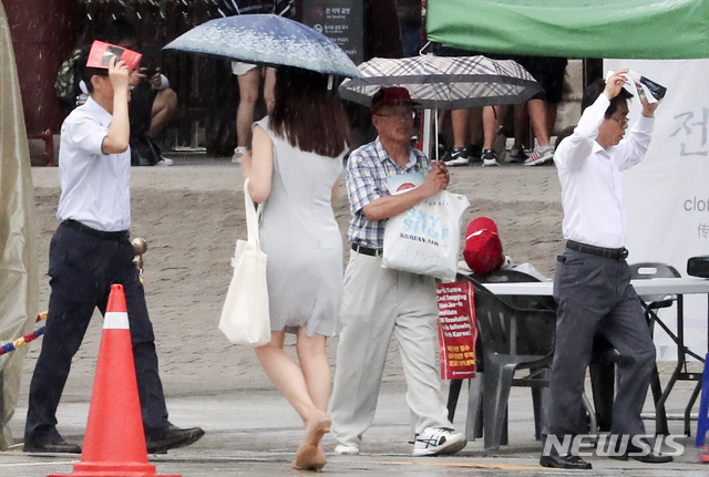 【서울=뉴시스】최진석 기자 = 전국 곳곳에 소나기가 내리고 있는 9일 오후 중구 서울광장 인근에서 시민이 내리는 비를 맞으며 발걸음을 재촉하고 있다. 기상청은 당분간 35도 안팎의 폭염이 이어지며, 밤에는 열대야가 계속되겠다고 밝혔다. 2018.08.09.&nbsp; myjs@newsis.com