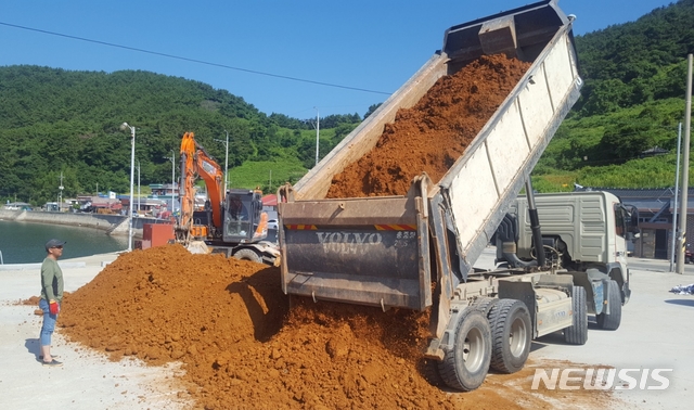 【통영=뉴시스】신정철 기자 = 경남 통영시 산양읍 연안에서 양식중인 어류에서 올들어 처음으로 적조 피해가 발생했다. 11일 통영시는 적조로 양식중인 말쥐치 2만 5000려마리가 폐사하자 기존 적조방제단의 규모를 늘려 황토살포에 나섰다. 통영시 산양읍 중화동에 야적된 황토가 해상에서의 살포를 위해 운반되고 있다. 2018.08.11. sin@newsis.com