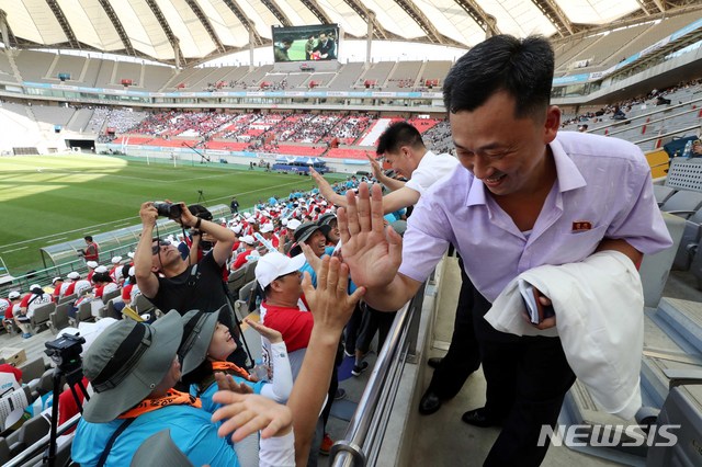 【서울=뉴시스】조성봉 기자 = 11일 오후 서울 마포구 상암 월드컵경기장에서 열린 남북노동자통일축구대회에서 시민들과 북측관계자들이 하이파이브를 하며 반갑게 인사하고 있다. 2018.08.11.suncho21@newsis.com