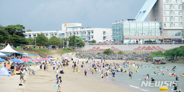 【부안=뉴시스】 김얼 기자 = 전북지역이 무더위가 한층 꺾이며 34도를 웃도는 날씨를 보인 11일 전북 부안군 변산면 모항 해수욕장에서 여름휴가를 즐기기 위해 피서온 관광객들이 넘실대는 파도를 맞으며 더위를 식히고 있다. 2018.08.11pmkeul@newsis.com