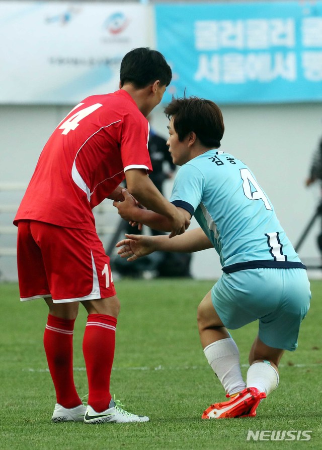 【서울=뉴시스】조성봉 기자 = 11일 오후 서울 마포구 상암 월드컵경기장에서 열린 남북노동자통일축구대회에서 조선직업총연맹 건설팀 선수가 넘어진 한국노총 김종현 선수를 일으켜세워주고 있다. 2018.08.11.suncho21@newsis.com