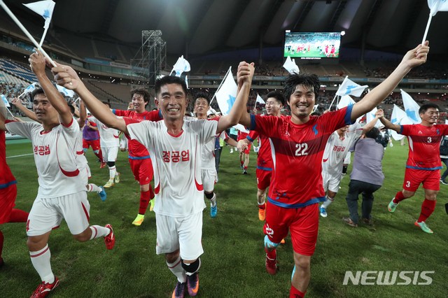 【서울=뉴시스】조성봉 기자 = 11일 오후 서울 마포구 상암 월드컵경기장에서 열린 남북노동자통일축구대회경기에서 남북노동자 선수들이 손을 맞잡고 경기장을 돌며 관중들에게 인사를 하고 있다. 2018.08.11. suncho21@newsis.com