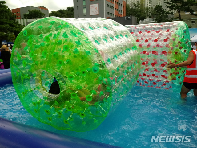 【서울=뉴시스】손대선 기자 = 11일 서울 은평구 혁신파크내에 마련된 에어풀장에서 아이들이 워터롤을 타고 있다.&nbsp; sds1105@newsis.com