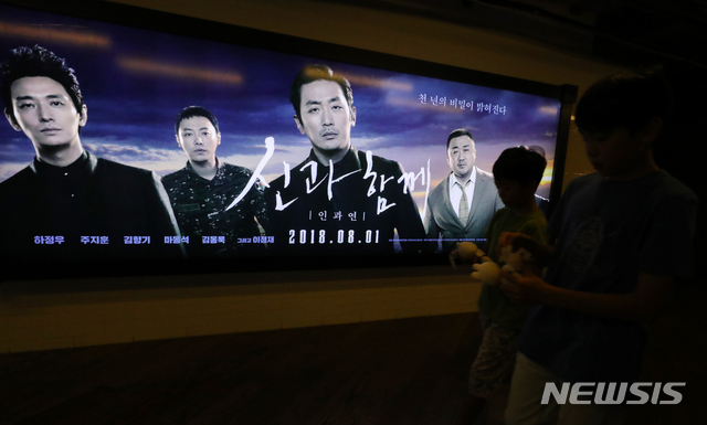 【서울=뉴시스】배훈식 기자 = 영화 '신과 함께-인과 연'이 개봉 11일만에 900만 관객을 돌파하며 전작에 이어 1000만 관객 달성을 눈앞에 둔 12일 오전 서울 강남구 코엑스 메가박스 포스터 앞을 관객들이 지나가고 있다. 2018.08.12. dahora83@newsis.com