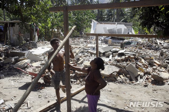【롬복 ( 인도네시아) = AP/뉴시스】 인도네시아 롬복섬 북부에서 12일 강진으로 무너진 집터에서 주민들이 임시 숙소를 마련하기 위해 애쓰고 있다. 롬복 인구의 10%인 39만명이 집을 잃고 노숙하고 있는 가운데 19일 다시 규모 6.9의 강진으로 섬 전역에 전기가 끊기고 건물들이 무너졌다. 2018.08.20&nbsp; 