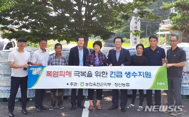 【옥천=뉴시스】이성기 기자 = 농협은행 충북 옥천군지부가 14일 옥천군 청산면에서 가뭄으로 급수난을 겪는 산간마을에 생수 5000병을 지원하고 있다.2018.08.14(사진=농협 옥천군지부 제공) photo@newsis.com