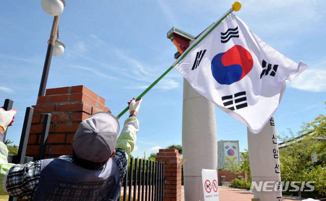 【대구=뉴시스】우종록 기자 = 광복절을 하루 앞둔 14일 오전 대구 동구 신암동 국립 신암선열공원 외벽에 관계자가 태극기를 걸고 있다. 2018.08.14. wjr@newsis.com