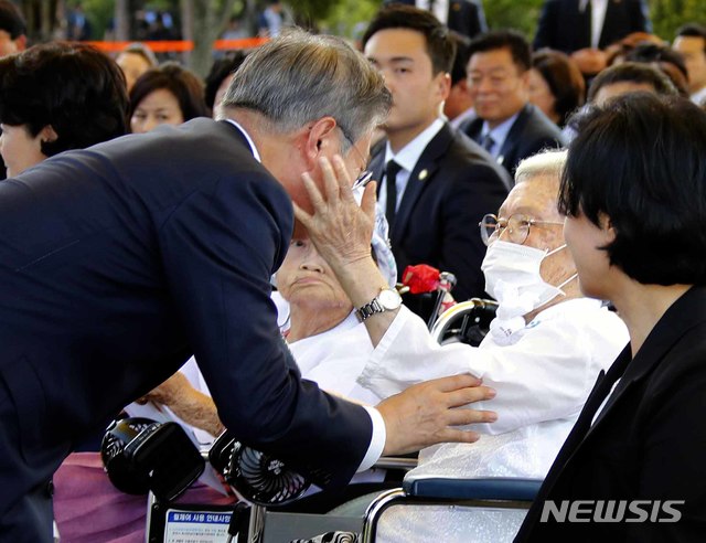 【천안=뉴시스】전신 기자 = 문재인 대통령이 14일 충남 천안 국립 망향의 동산에서 열린 일본군 위안부 피해자 기림의 날 기념식에 입장하며 김경애 할머니와 인사하자 할머니가 대통령 얼굴을 만져보고 있다. 2018.08.14. photo1006@newsis.com