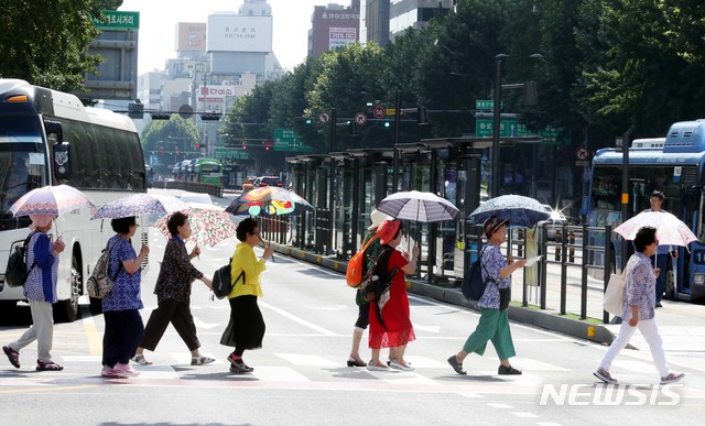 【서울=뉴시스】조성봉 기자 = 폭염이계속되는 15일 오전 서울 종로구 광화문 네거리에서 양산을 쓴 시민들이 무더위에 발걸음을 제촉하고 있다 .2018.08.15.suncho21@newsis.com