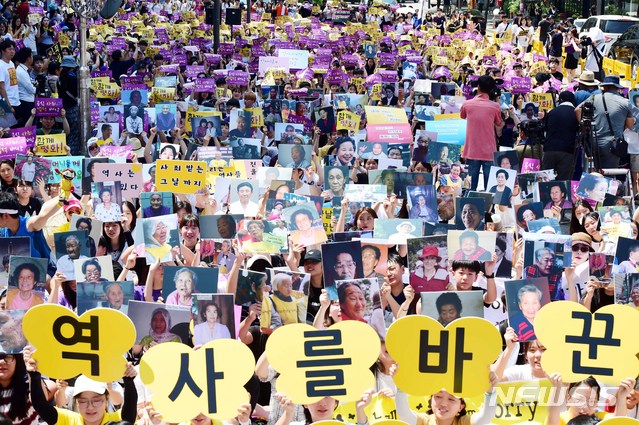 【서울=뉴시스】조성봉 기자 = 제73주년 광복절인 15일 오후 서울 종로구 옛 일본대사관 앞 평화로에서 열린 ‘제6차 세계 일본군위안부 기림일 맞이 세계연대집회 1348차 정기수요시위’에서 참가자들이&nbsp; 위안부 할머니들의 사진을 들고&nbsp; ‘함께 평화‘ , '공식사죄' 구호를 외치고 있다. 2018.08.15.suncho21@newsis.com