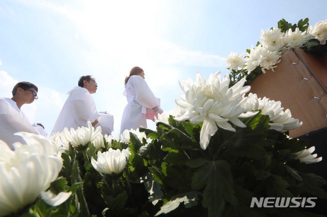 【서울=뉴시스】조성봉 기자 = 15일 오후 서울 종로구 광화문 광장에서 열린 일제강제징용희생자 유해봉환 국민추모제에서 유해봉환위 관계자들이 희생자 35위를 제단에 모시고 있다. 이번 추모제는 한국민족종교협의회, 일제강제징용희생자 유해봉환위원회 등이 제73주년 8.15광복절 민족공동행사로 진행했다. 2018.08.15.suncho21@newsis.com